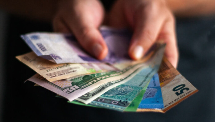 A Person holding Malaysian Notes and USd bills